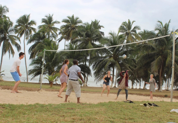 a group of people are playing volleyball on a beach .