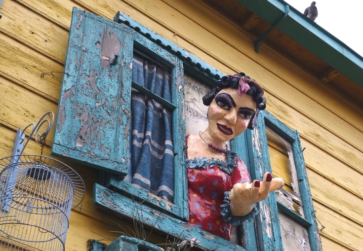 a statue of a woman is looking out of a window .