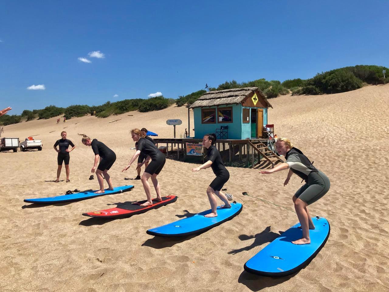 a group of people are standing on surfboards on a beach .