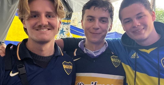 three young men are posing for a picture with one wearing a quilmes jersey