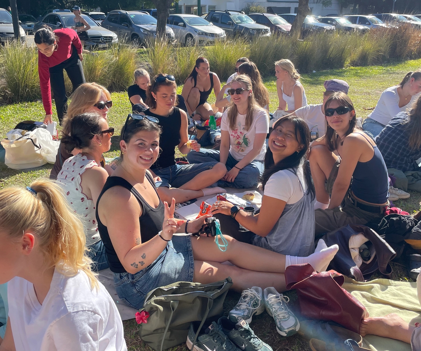 a group of people are sitting on the grass in a park .