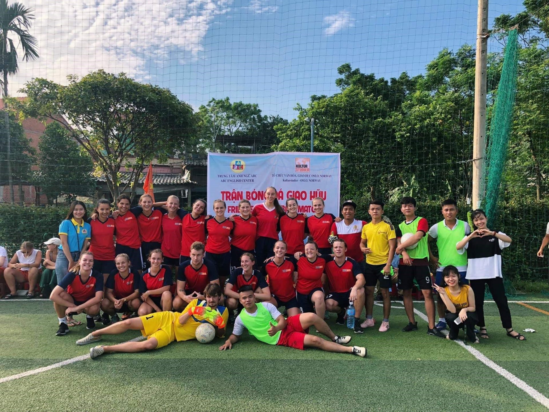 a group of people are posing for a picture on a soccer field .