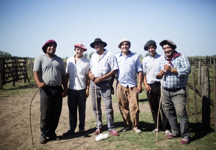 a group of men are standing next to each other in a field .