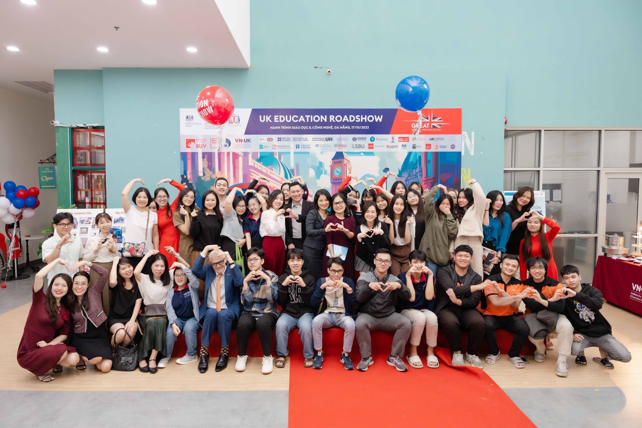 a large group of people are posing for a picture on a red carpet .