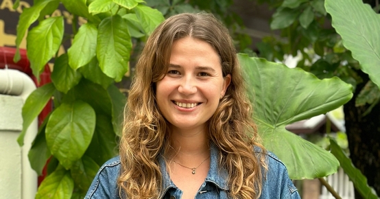 a woman wearing a denim jacket and a yellow dress