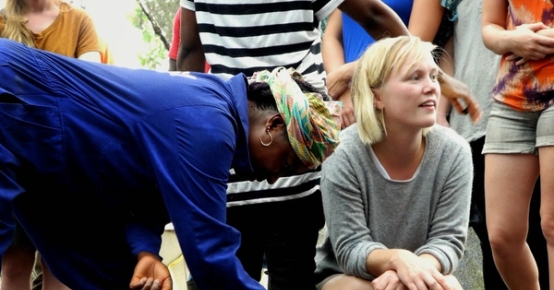 a woman is kneeling down next to a woman in a blue shirt