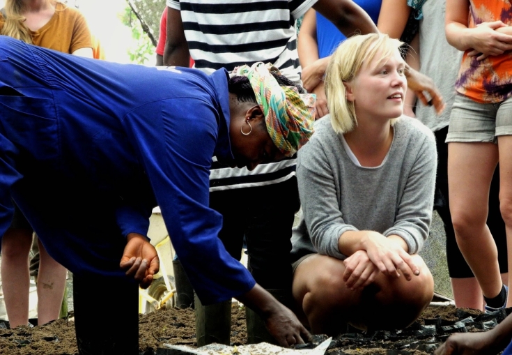 en kvinde knæler ned ved siden af en kvinde i en blå skjorte