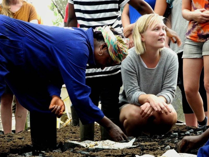 a woman is kneeling down next to a woman in a blue shirt