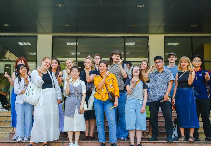 en gruppe mennesker som står foran en bygning som sier chua linh ung