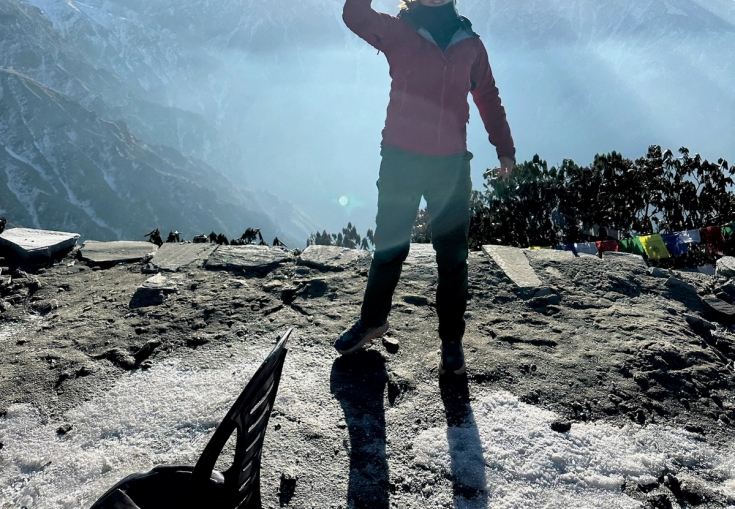 en person står på toppen af et bjerg med et orange flag