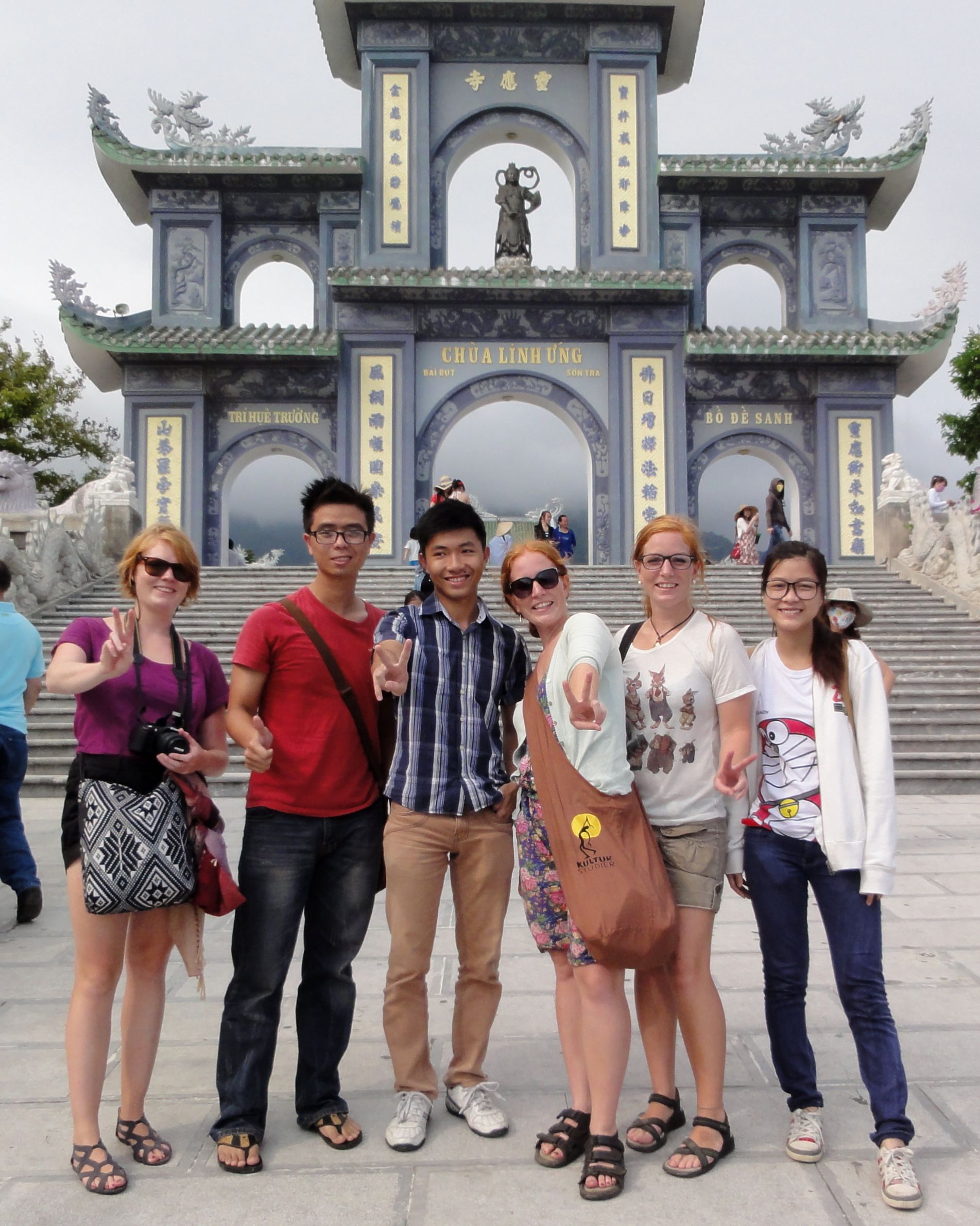 a group of people standing in front of a building that says chua linh ung