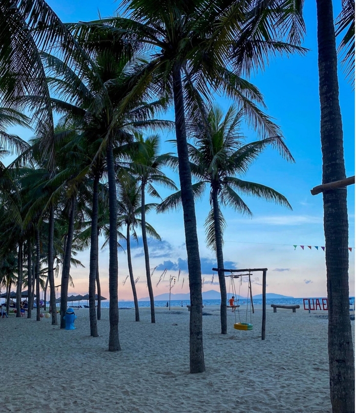 a beach with palm trees and swings and a sign that says luap