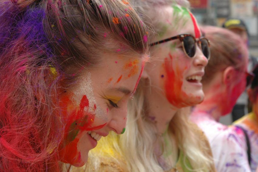 a group of women with their faces covered in colored powder.
