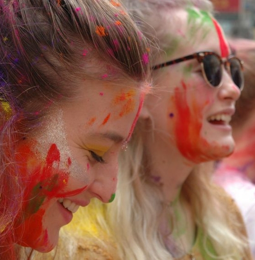 a group of women with their faces covered in colored powder.