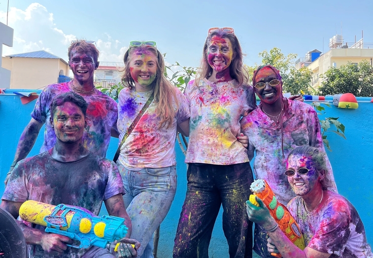a group of people covered in colored powder are posing for a picture