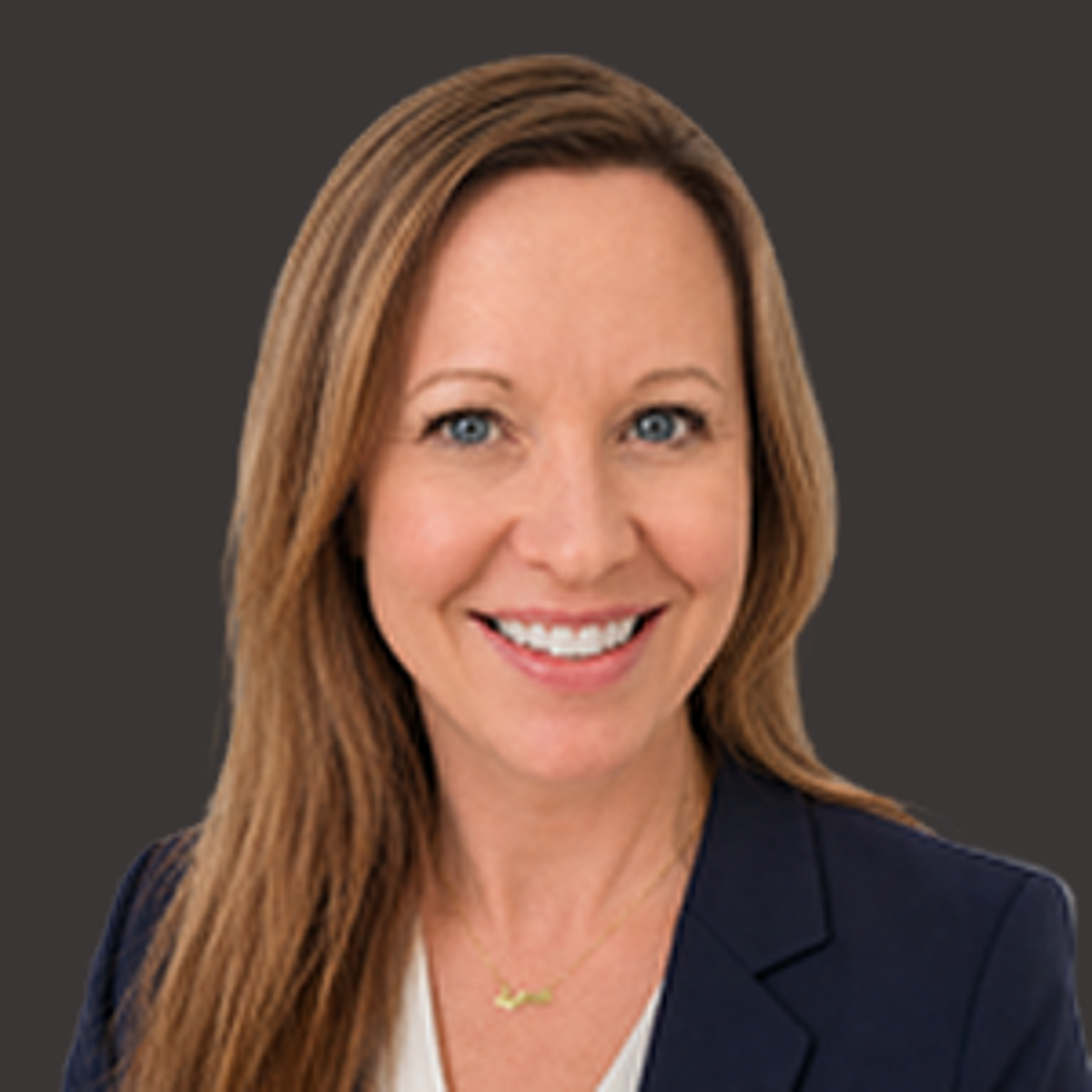 Smiling woman with long light brown hair wearing a navy blazer and white top, posed against a plain dark background.
