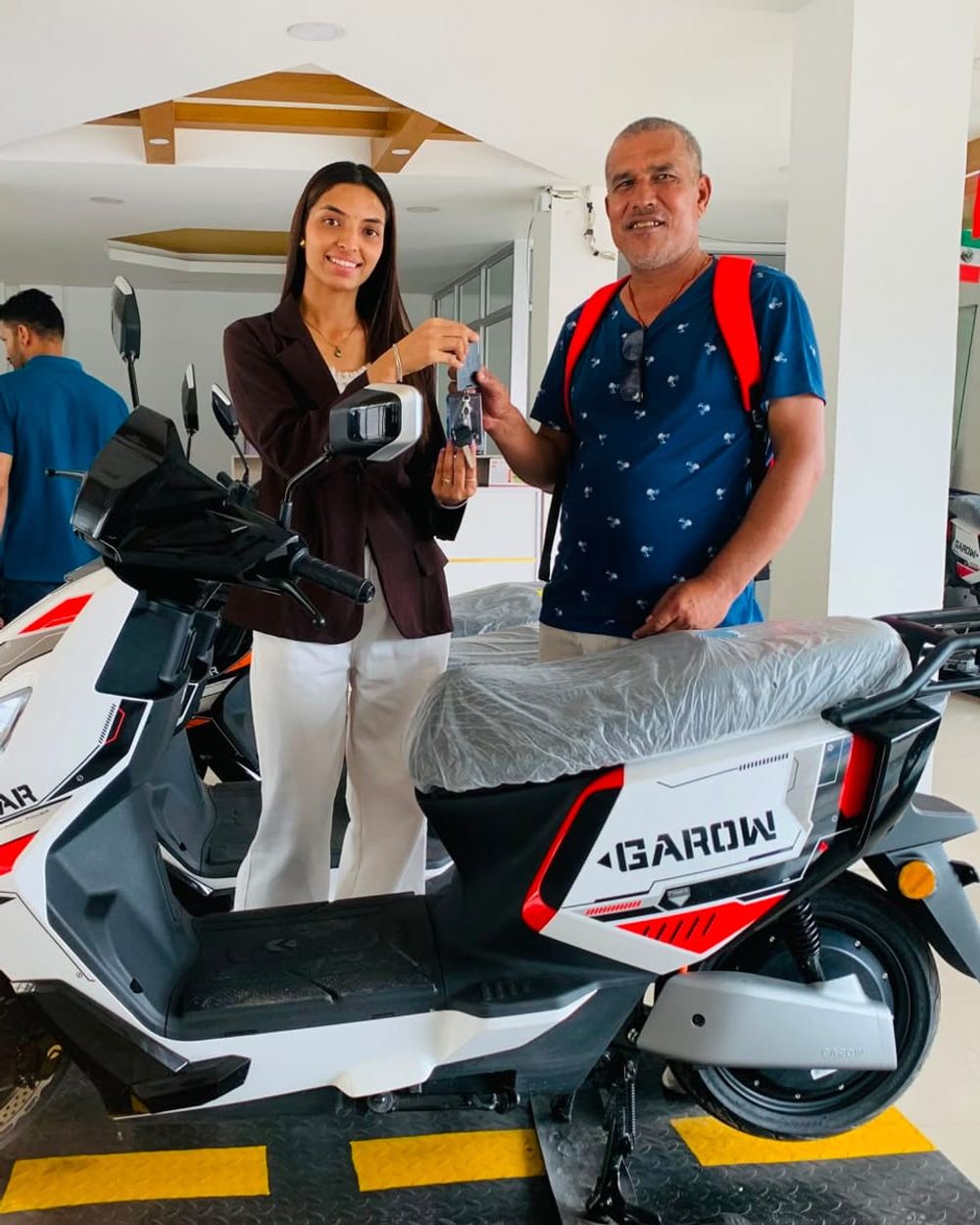 Keys changing hands beside a white Garow scooter