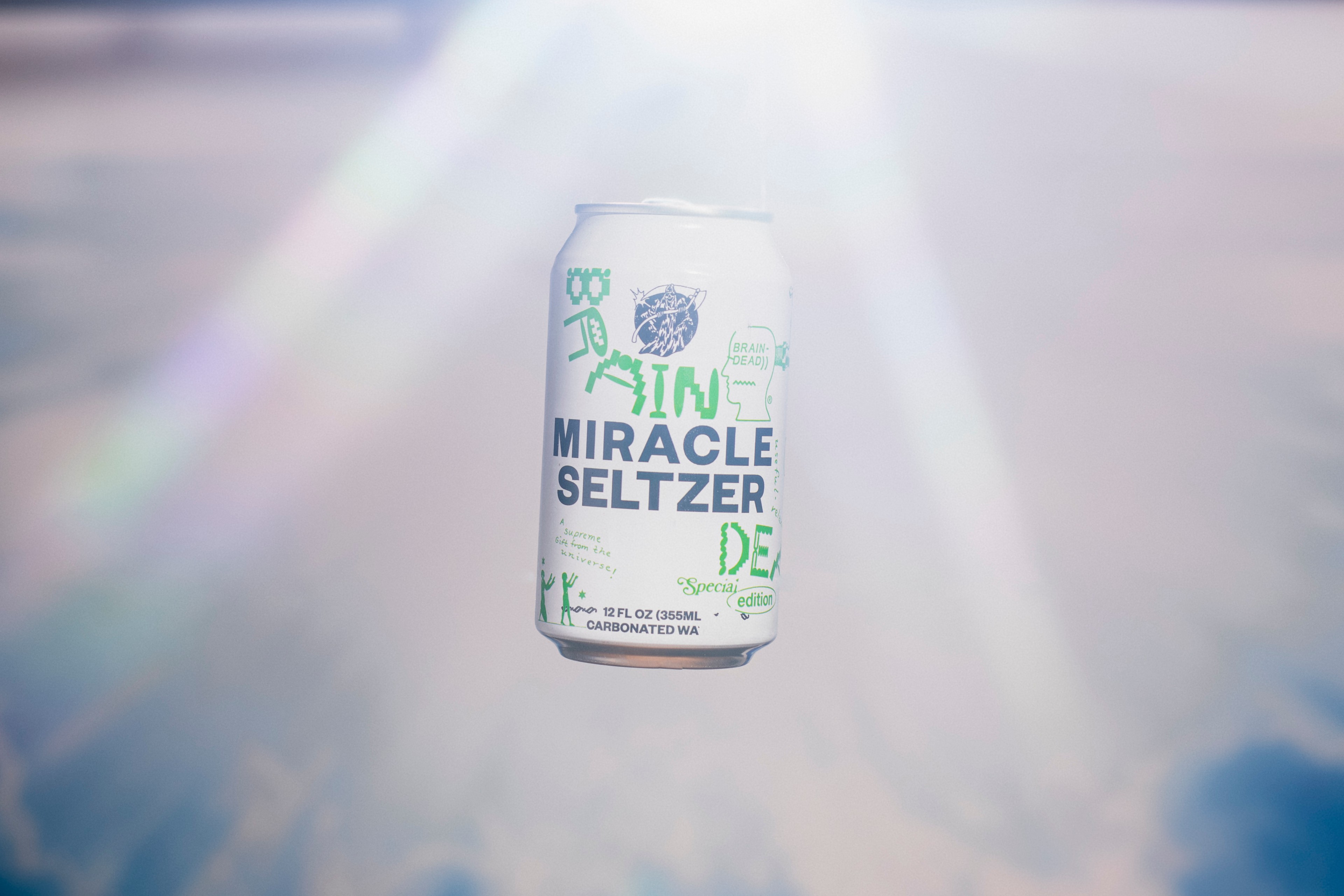 photo of miracle seltzer can floating above the sky with lens flare