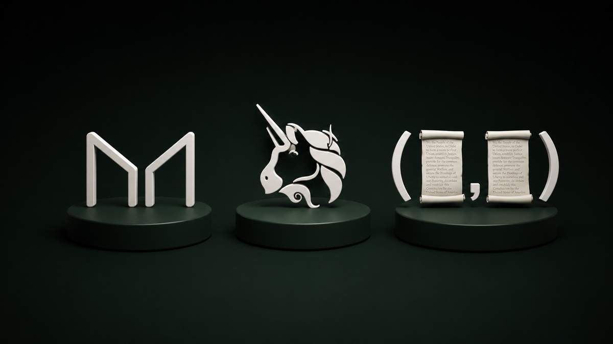 Three decorative sculptures on pedestals: a stylized letter 'M', a unicorn, and two scrolls with text.
