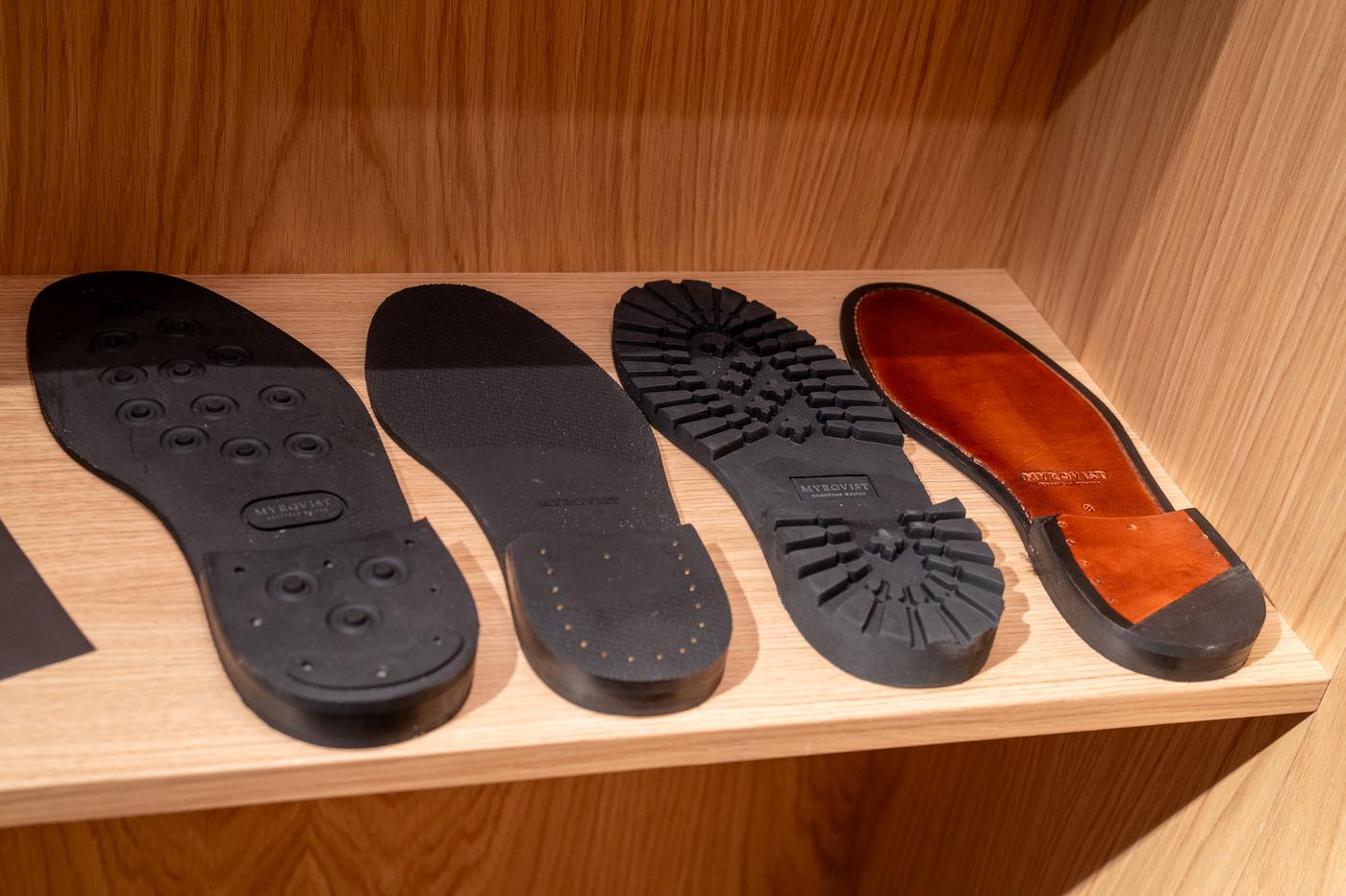 there are many different types of shoe soles on a wooden shelf .