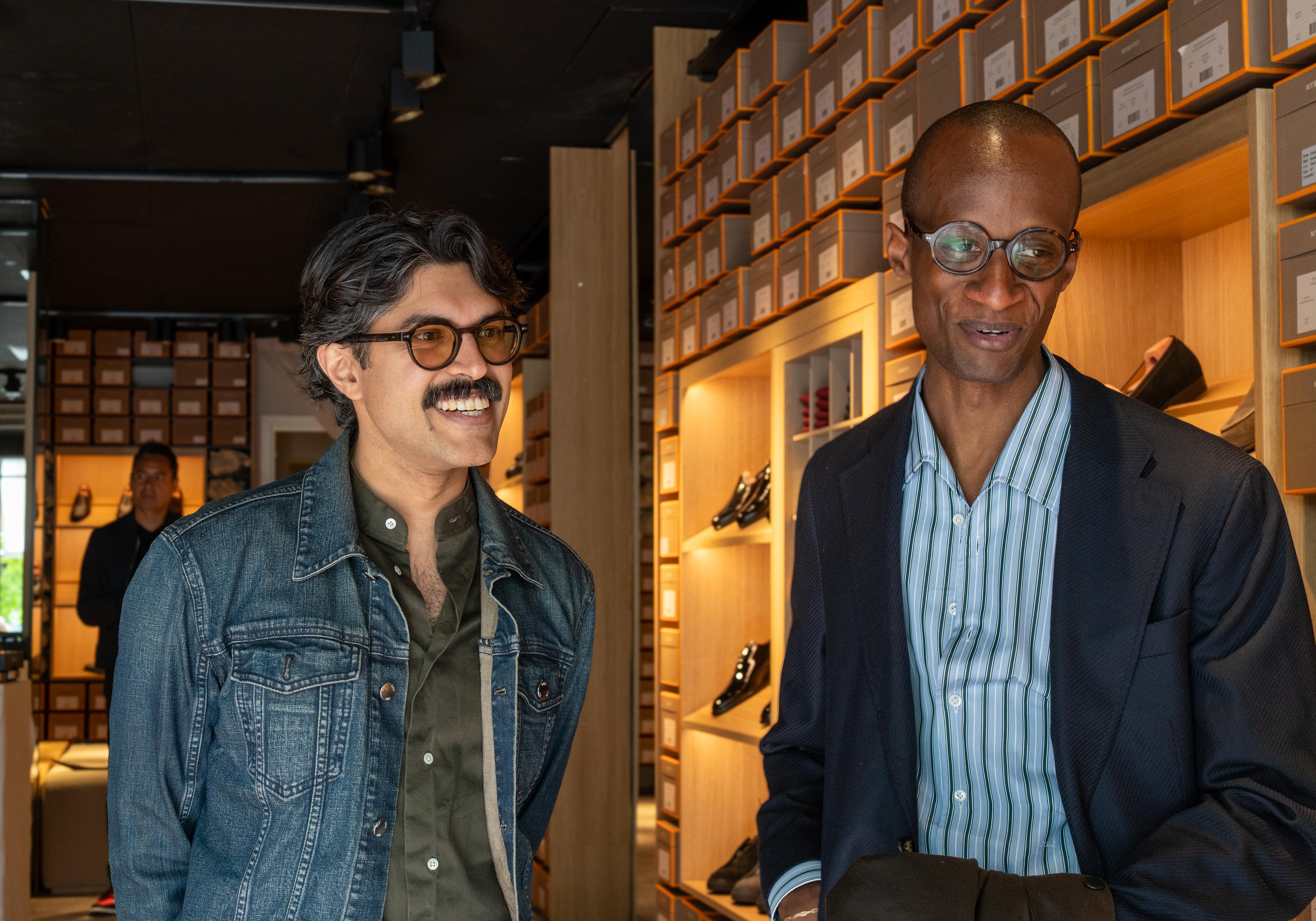 two men are standing next to each other in a shoe store .