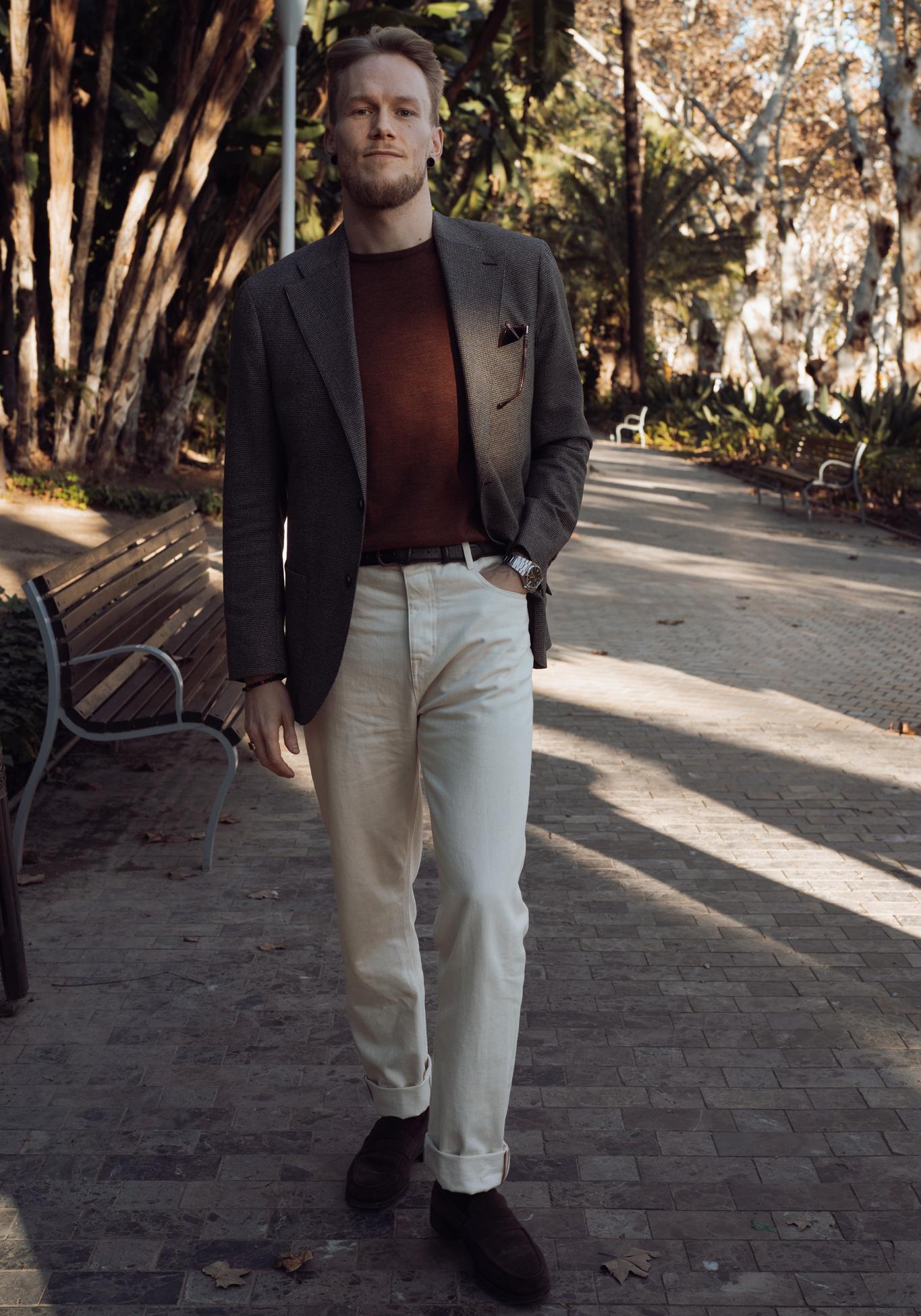 Man wearing a blazer, sweater and white trousers and loafers