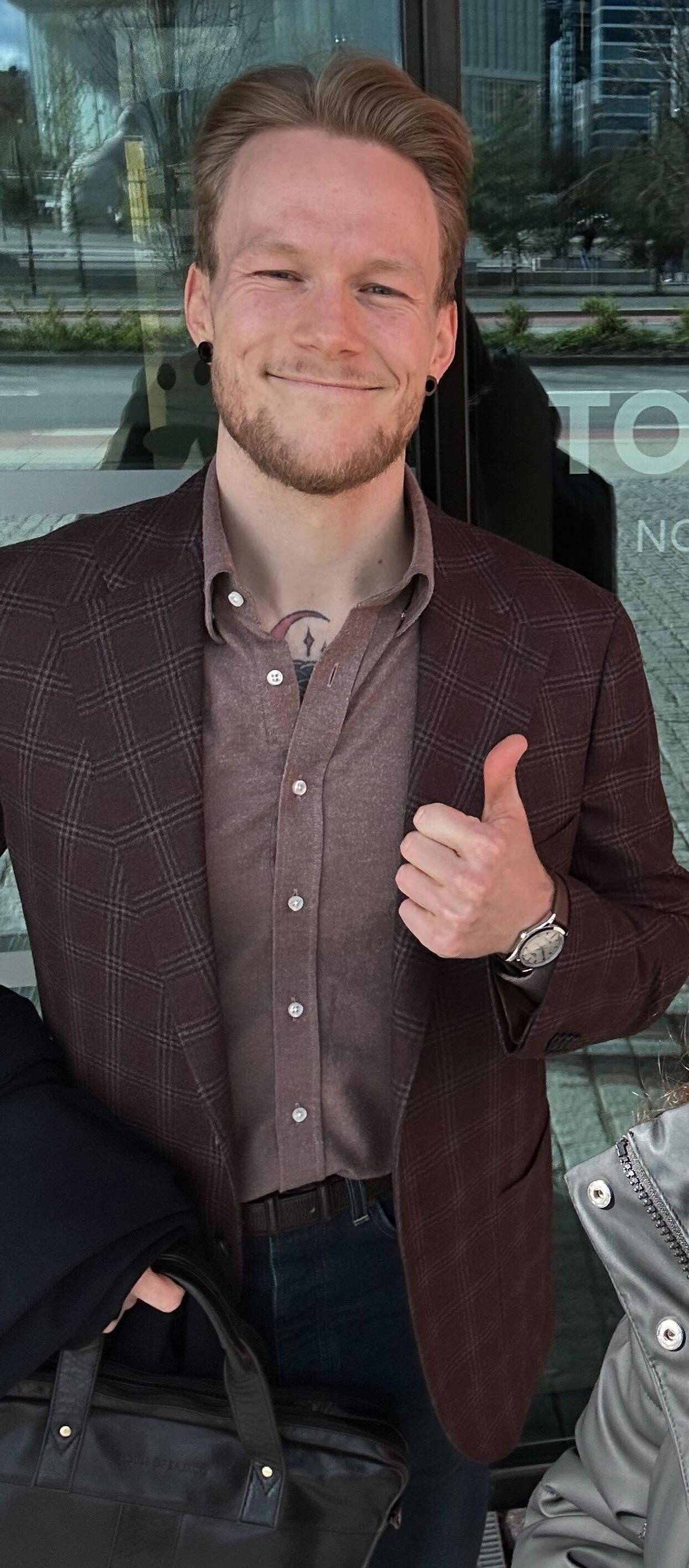 a man and a woman are standing in front of a sign that says tolletaten norwegian customs