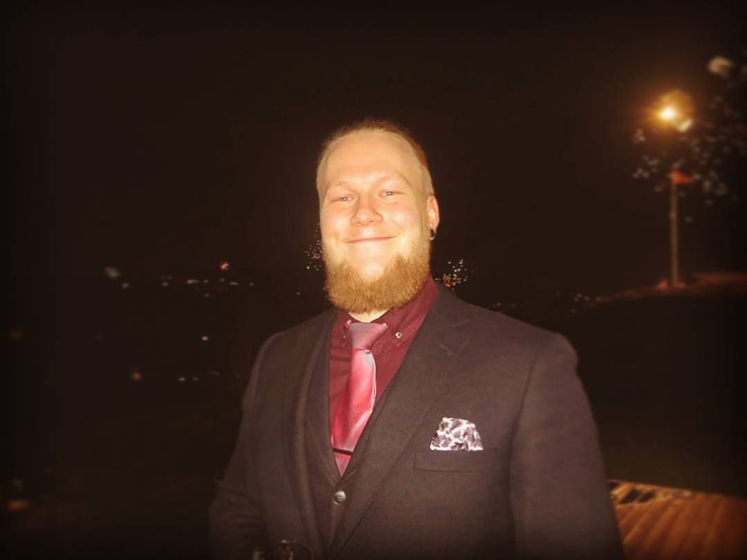 Smiling guy in suit with red shirt and tie