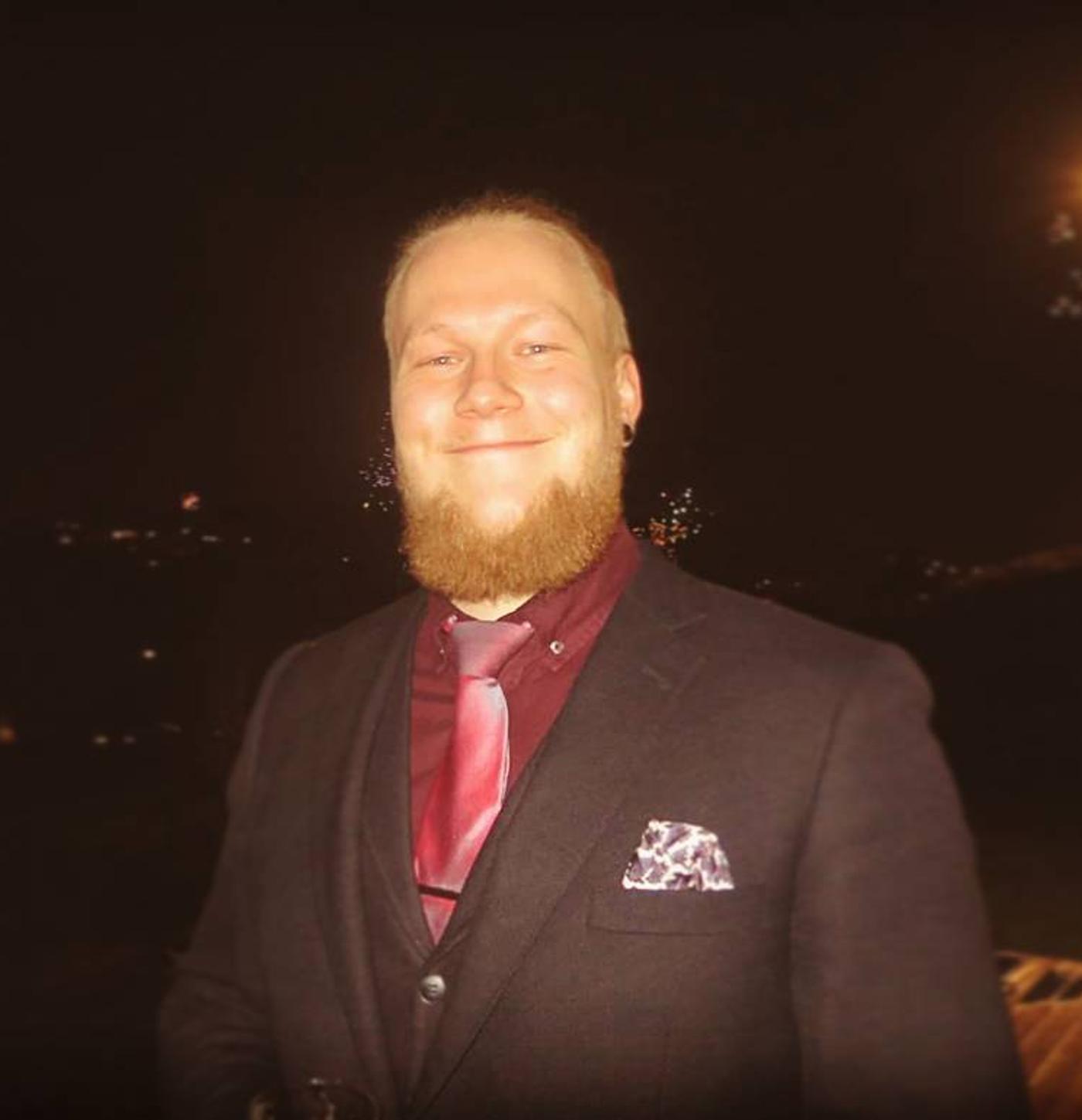Smiling guy in suit with red shirt and tie