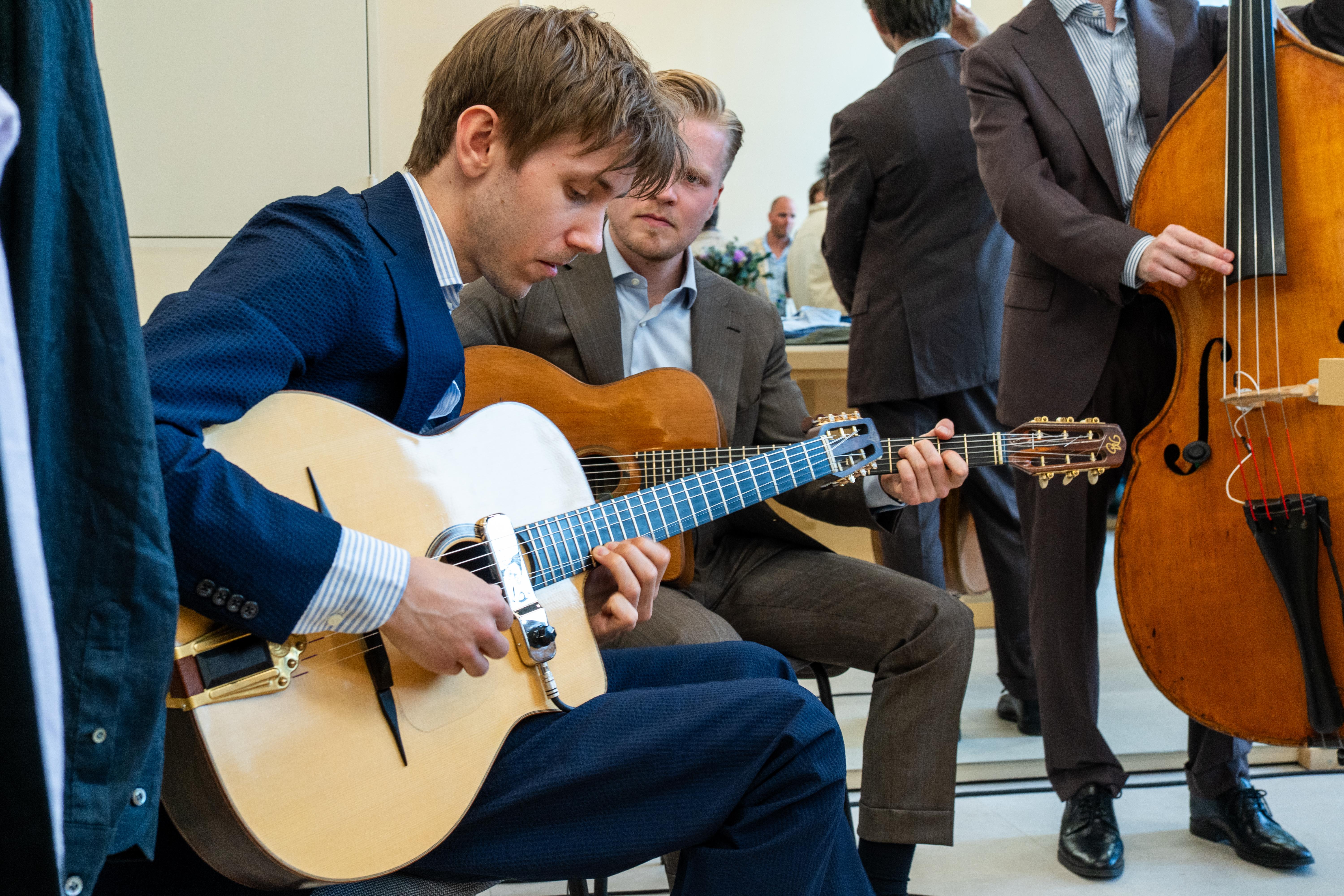 a man is playing a guitar while another man plays a double bass .