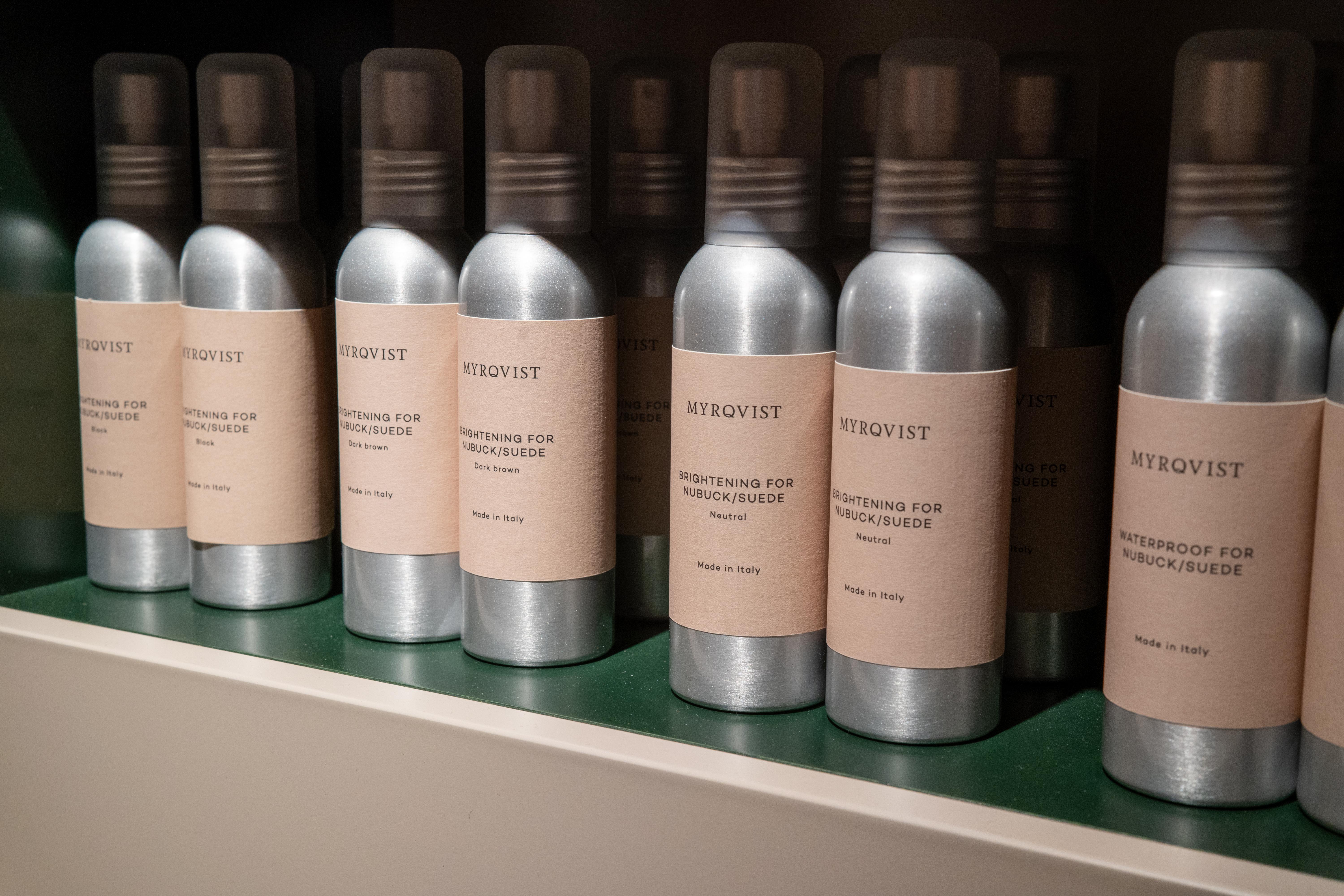 a row of spray bottles sitting on top of a shelf .