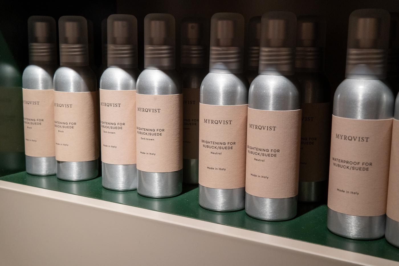 a row of spray bottles sitting on top of a shelf .