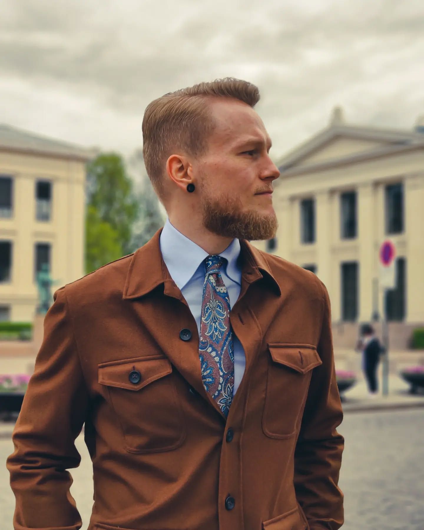 Man wearing a shirt and tie paired with an overshirt