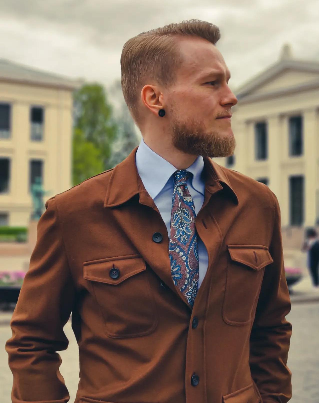 Man wearing a shirt and tie paired with an overshirt