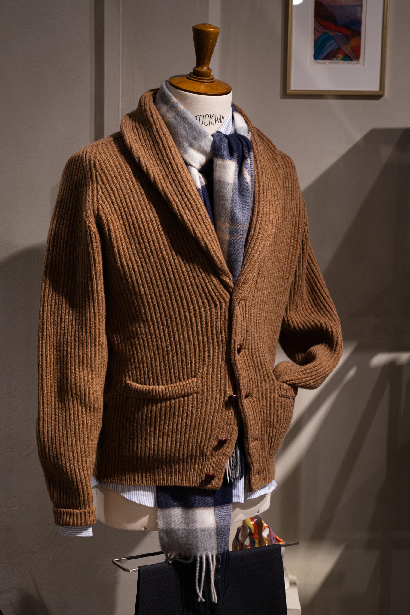 Mannequin wearing a brown ribbed cardigan and a blue and white plaid scarf.