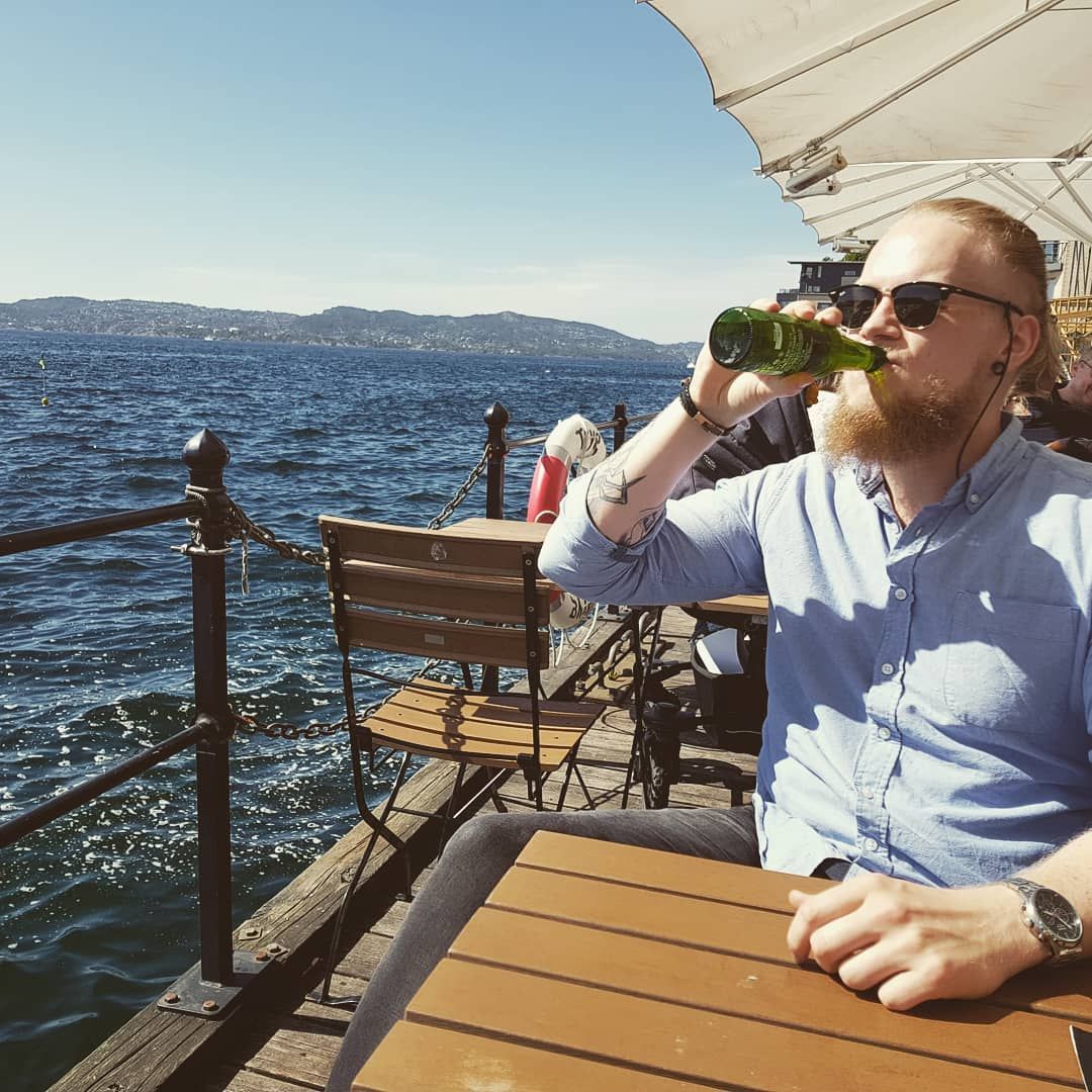 Kristoffer drinking beer in the sun by the water