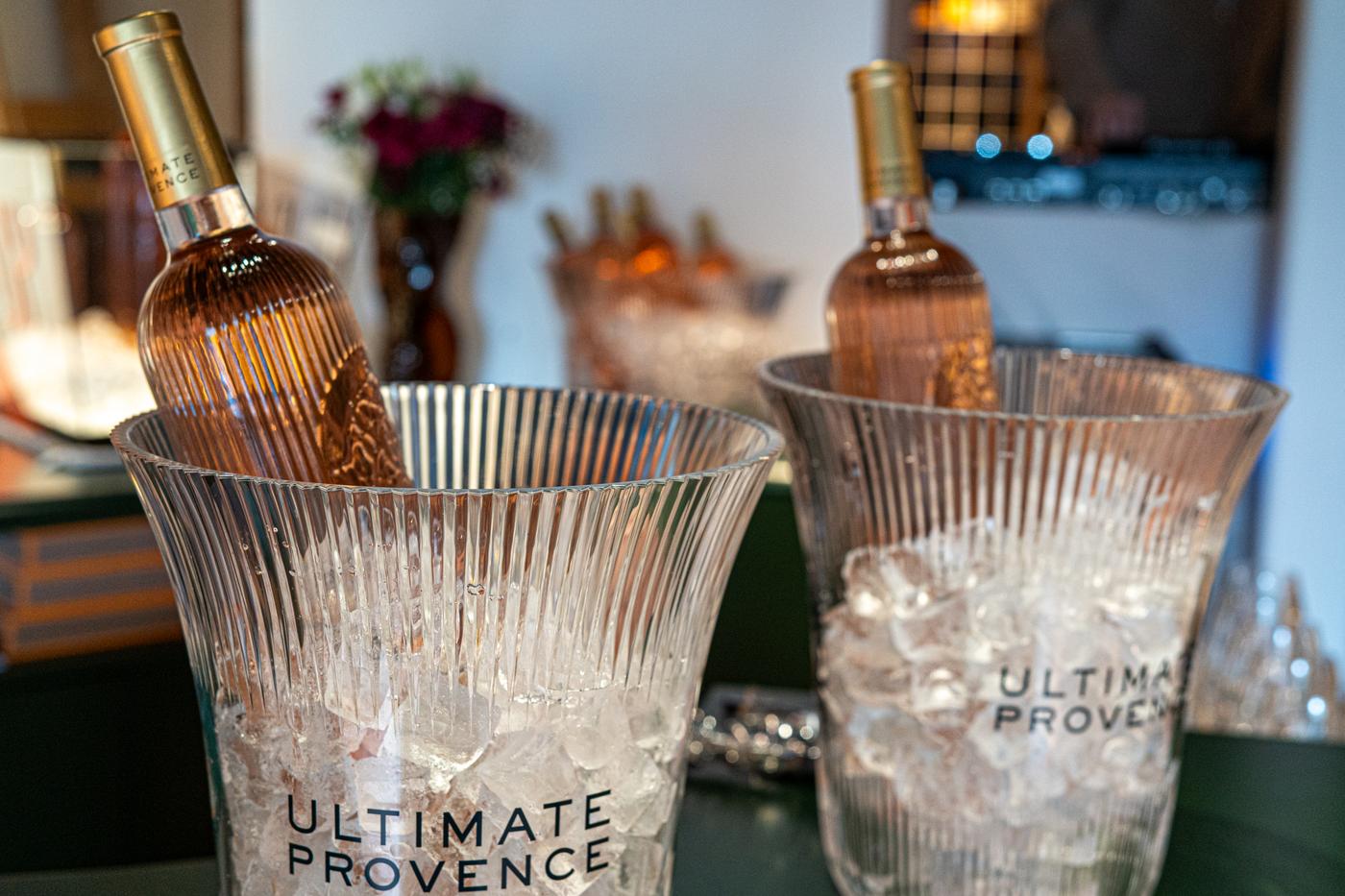 two buckets of ice with bottles of wine in them on a table .