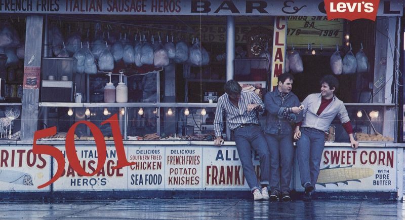 Vintage Levi's 501 ad featuring three men in jeans leaning on a street food stand, with a large red "501" overlay.