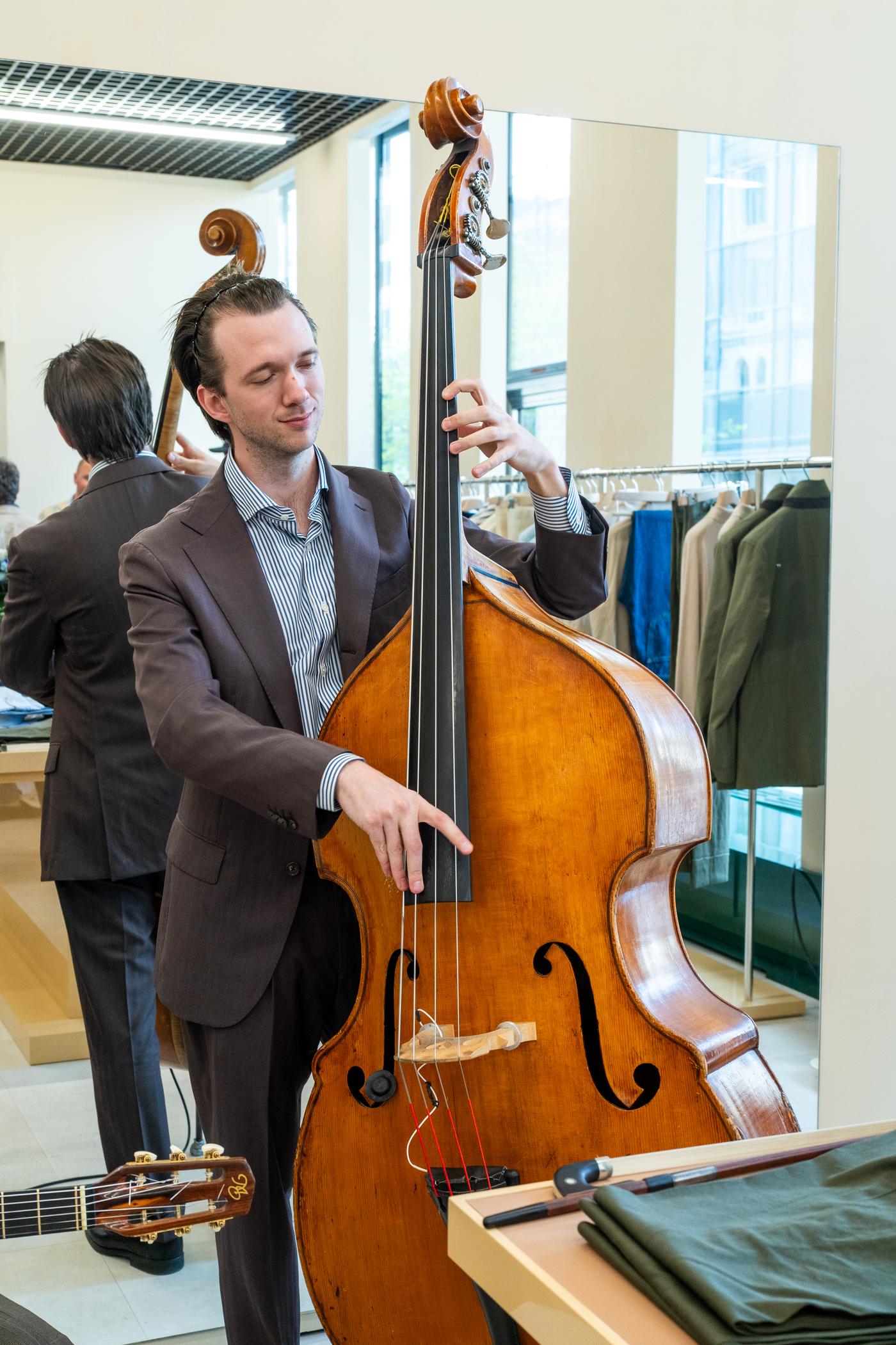 a man in a suit is playing a double bass