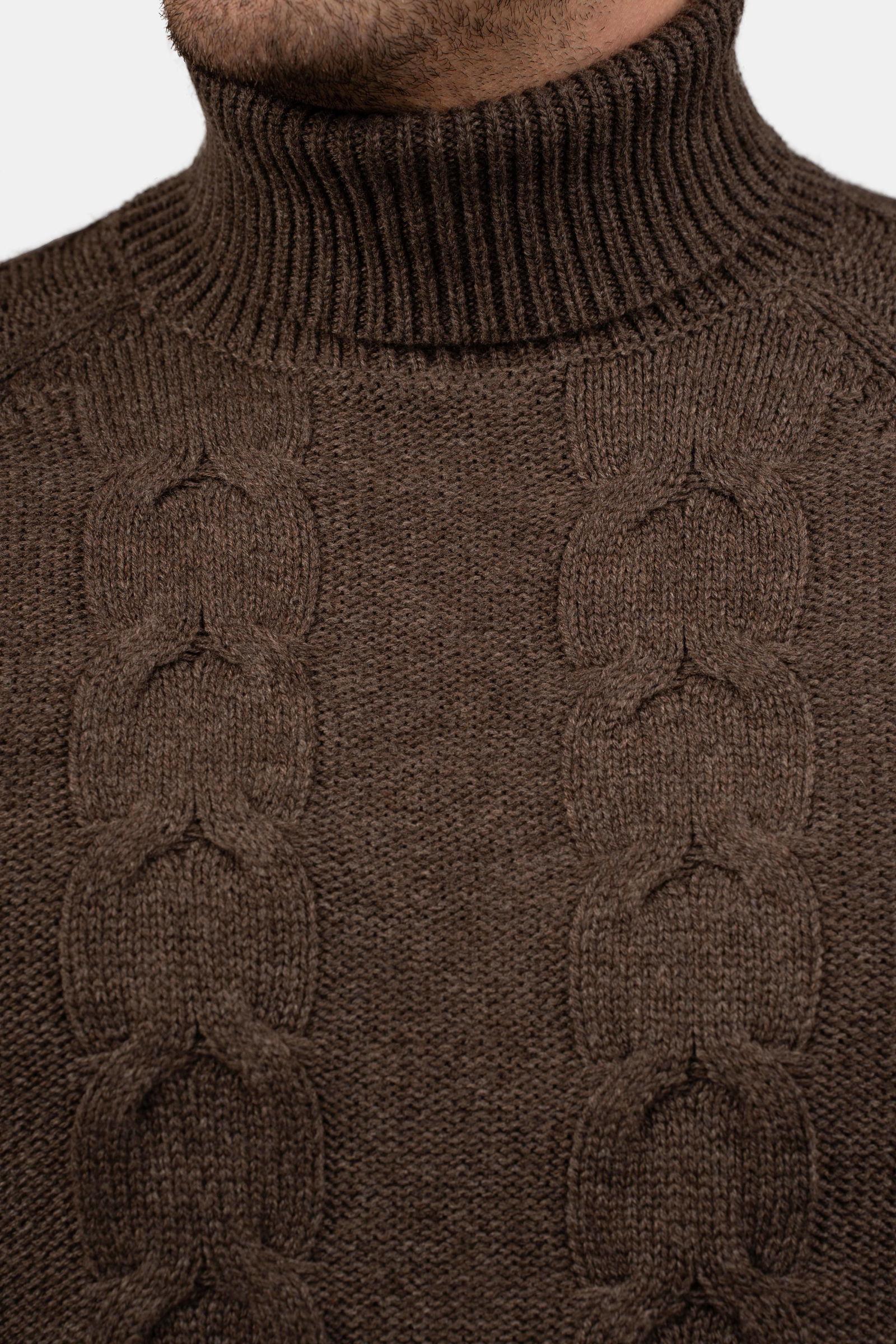 Close-up of a man wearing a brown cable-knit turtleneck sweater.