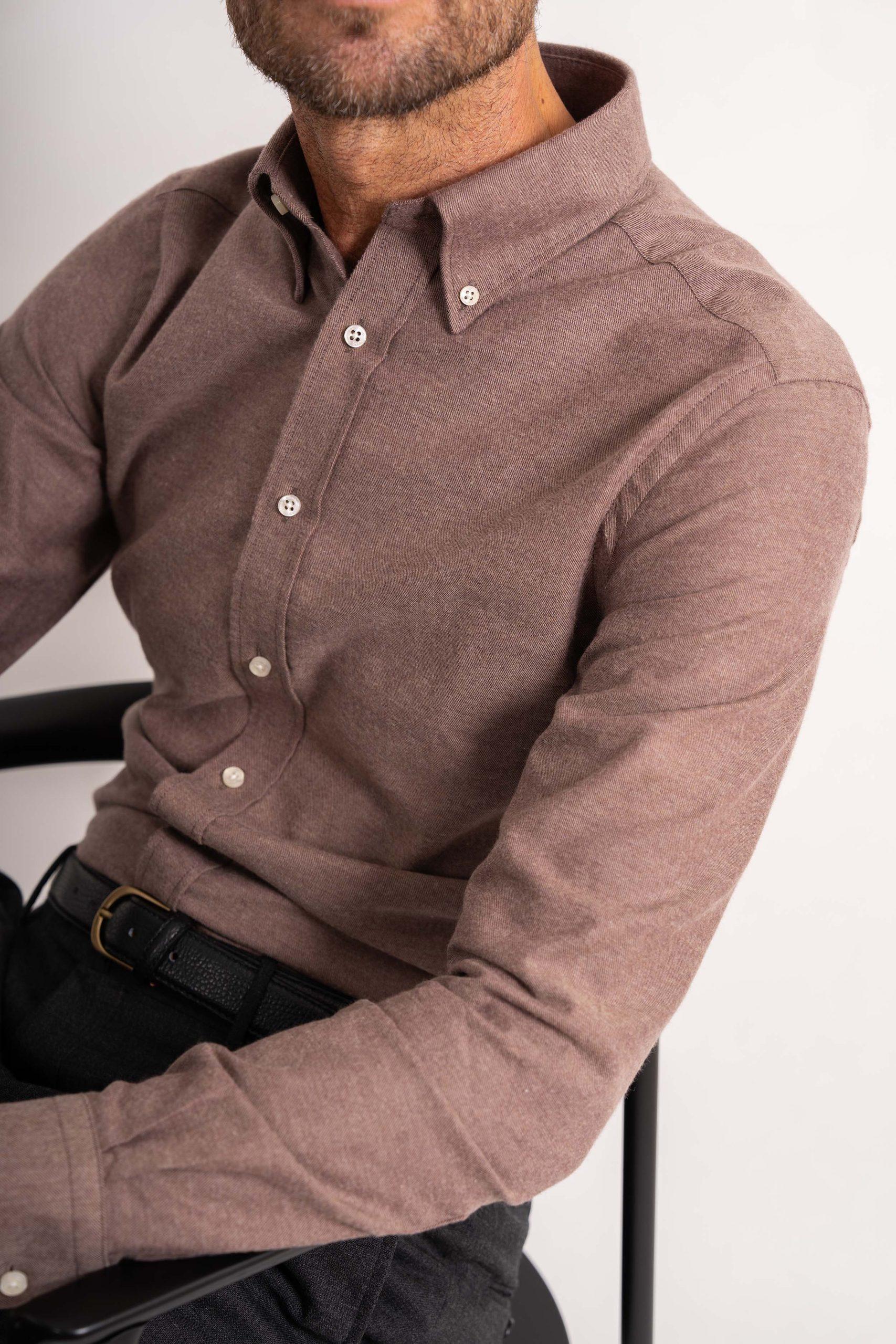 a man is wearing a brown button down shirt