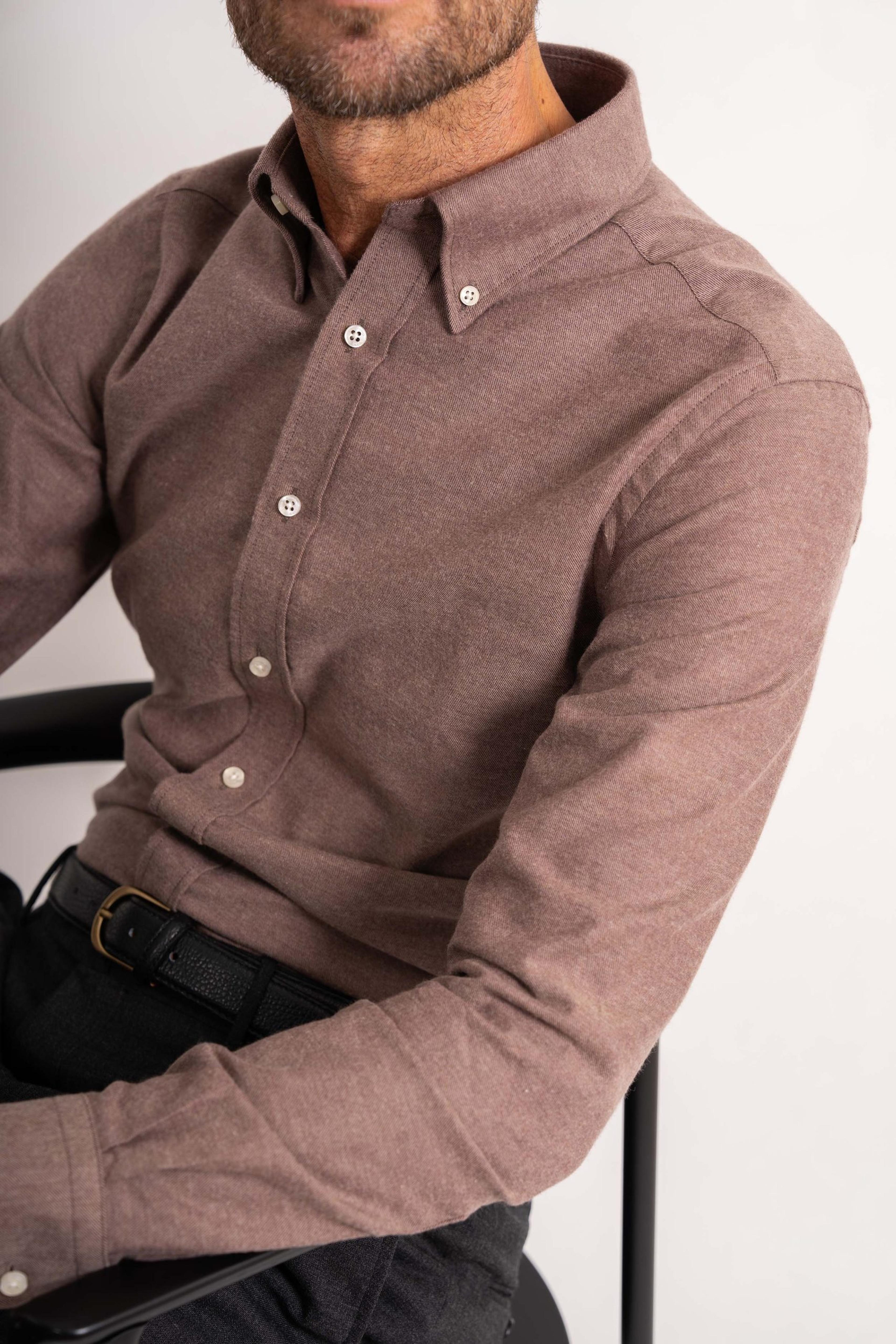 a man is wearing a brown button down shirt