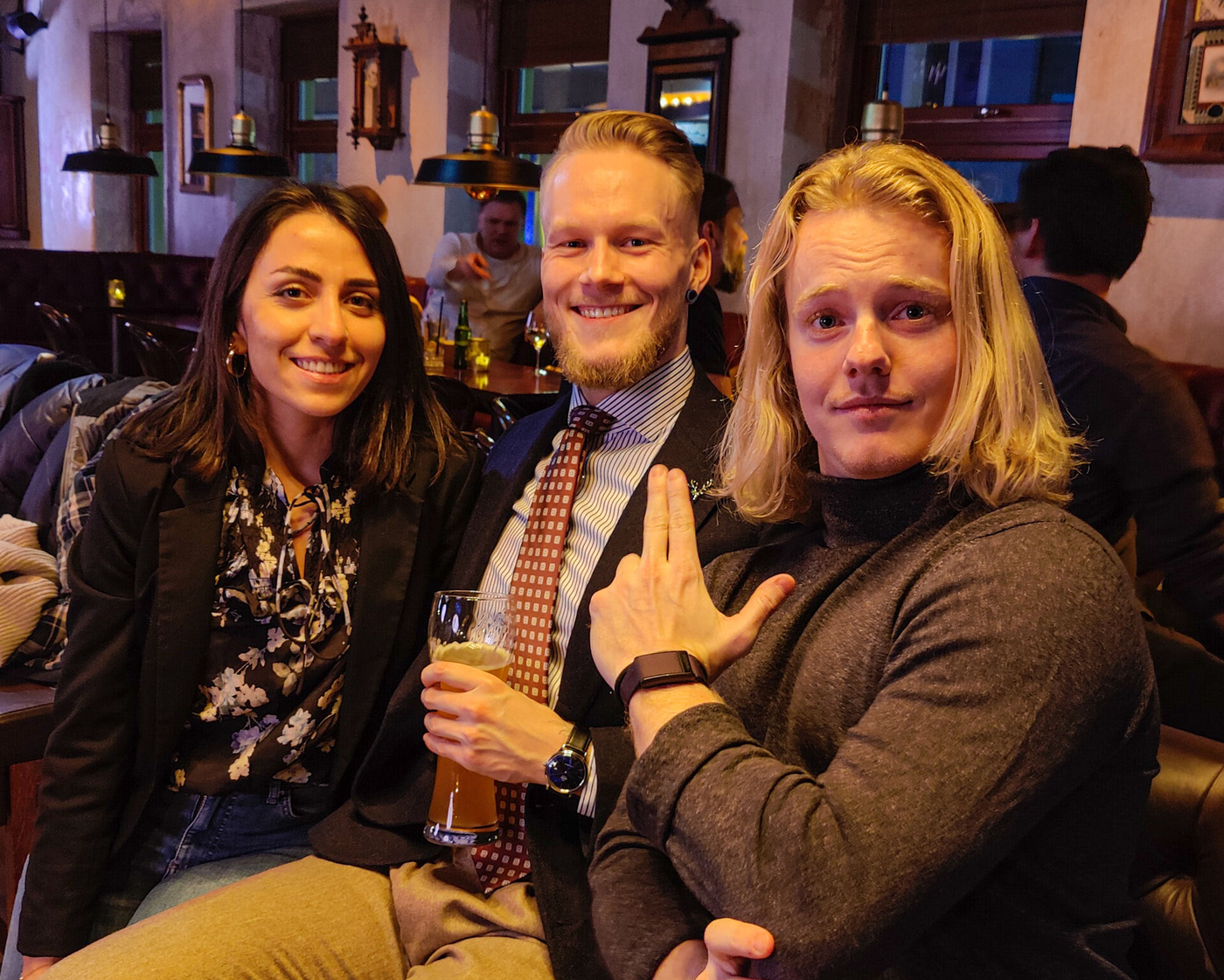 Kristoffer with his parter and cousin. He is wearing a shirt, tie and navy jacket, paired with beige flannel trousers
