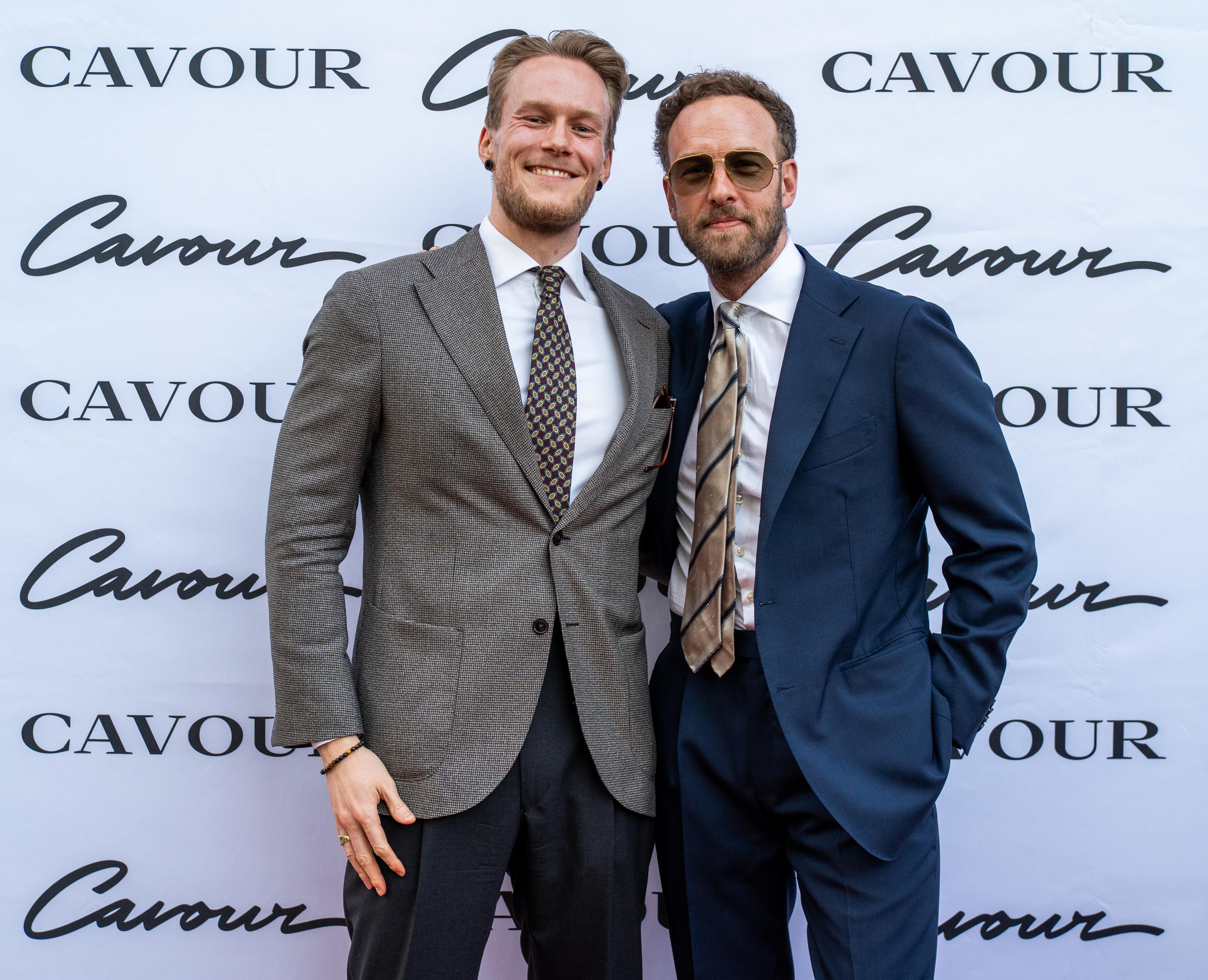 two men in suits and ties are posing for a picture .