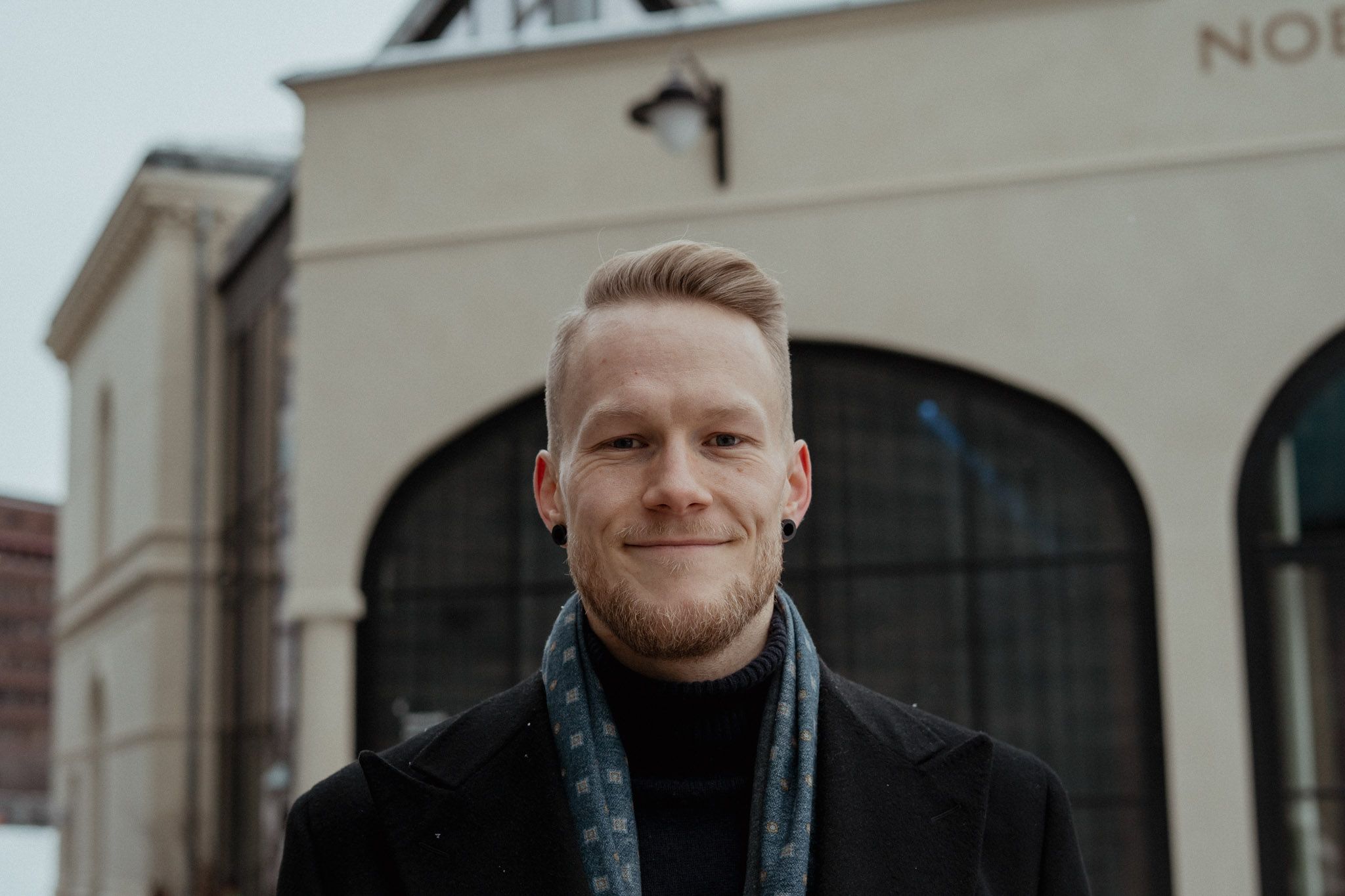 Smiling man wearing a scarf and turtleneck