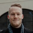 Smiling man wearing a scarf and turtleneck
