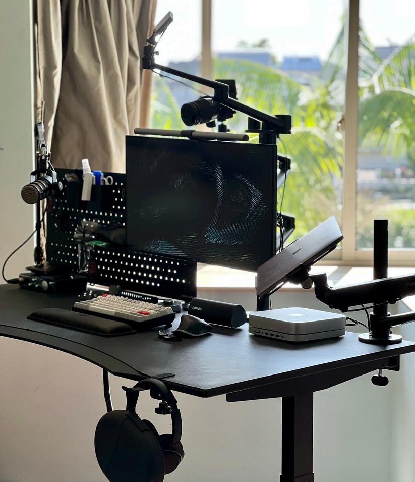 Ajmal Afif‘s latest workstation snapshot as of Jan 2022 which consist of myriad of tech hardwares like a monitor, a laptop, Mac mini, keyboard, mouse, microphone, camera and more.
