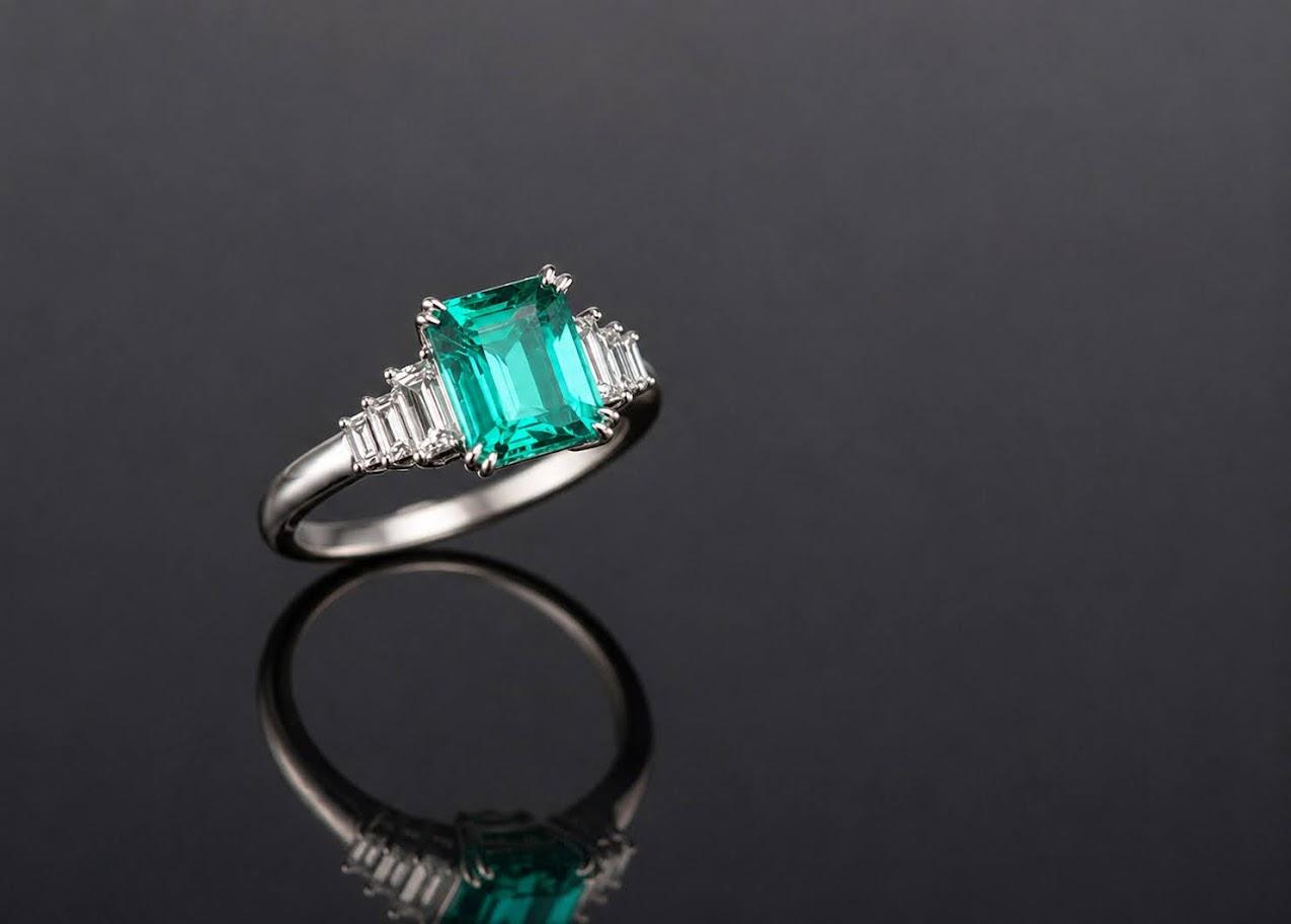 Emerald-cut emerald ring, diamond shoulders, white gold, angled