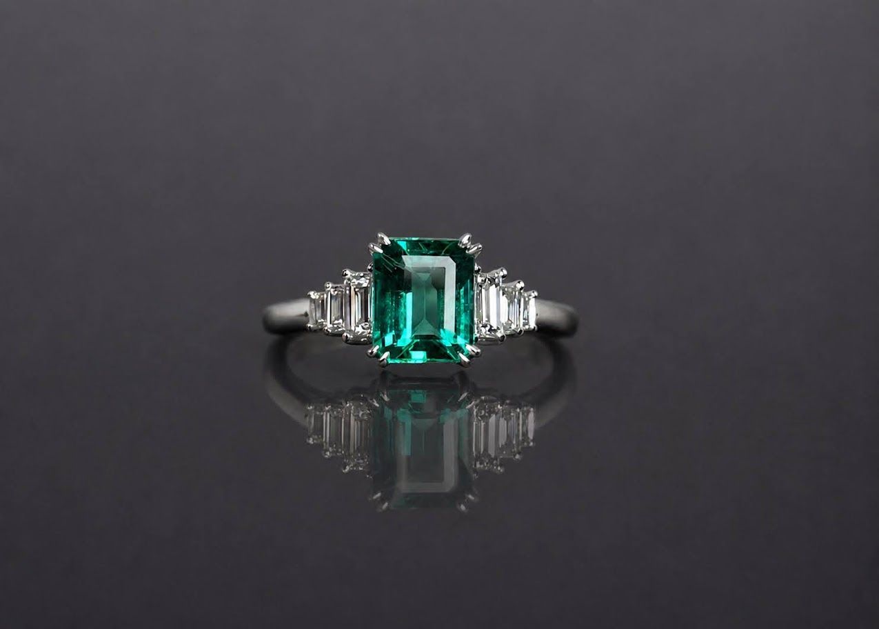 Emerald-cut green emerald, step-cut diamond sides, white gold