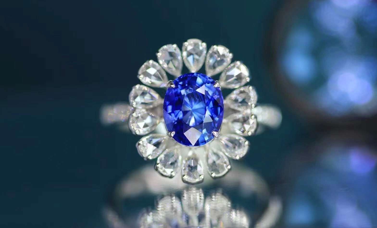 A blue sapphire ring surrounded by a halo of pear-shaped rose-cut diamonds